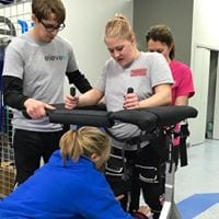 Girl using the Gait Harness System with therapists